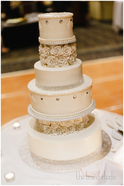 Six layer ivory wedding cake with crystals and rosettes at a Sheraton Station Square, Pittsburgh wedding.